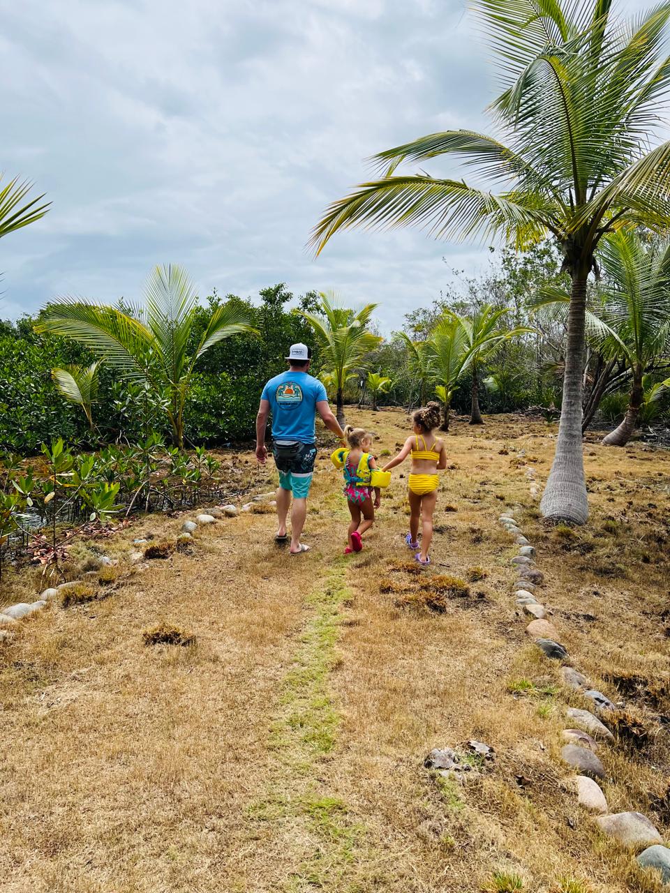 Family walking a palm-lined island path on Glamp Island, Bocas del Toro