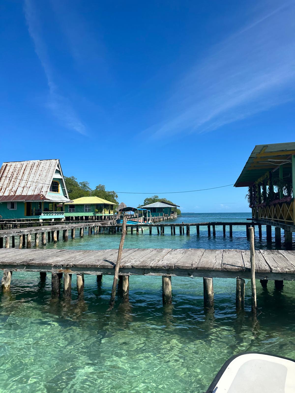 Overwater restaurant on stilts with wooden dock and clear Caribbean water, Bocas del Toro